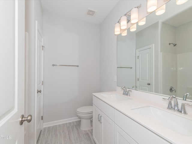 bathroom featuring vanity, toilet, and a shower