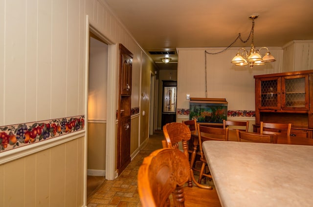 dining room with ornamental molding and an inviting chandelier