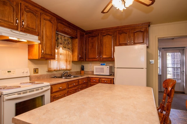 kitchen with white appliances, ceiling fan, dark colored carpet, and sink