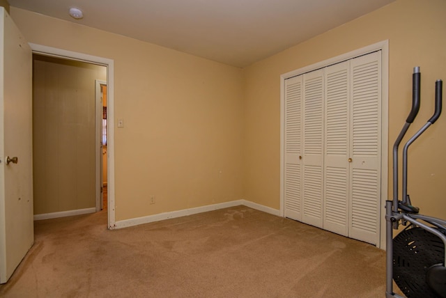 unfurnished bedroom with light colored carpet and a closet