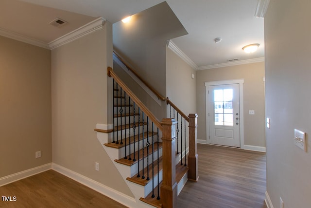 stairway with crown molding and hardwood / wood-style floors