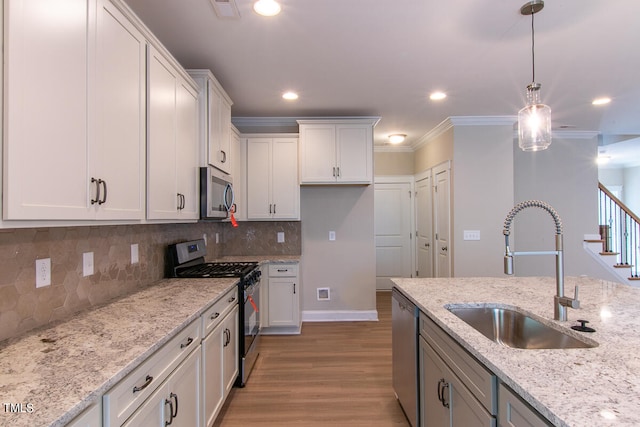 kitchen featuring white cabinetry, light hardwood / wood-style floors, sink, crown molding, and stainless steel appliances