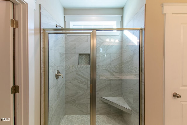 bathroom featuring a shower with shower door