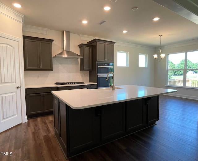 kitchen with dark hardwood / wood-style floors, sink, wall chimney range hood, and gas stovetop