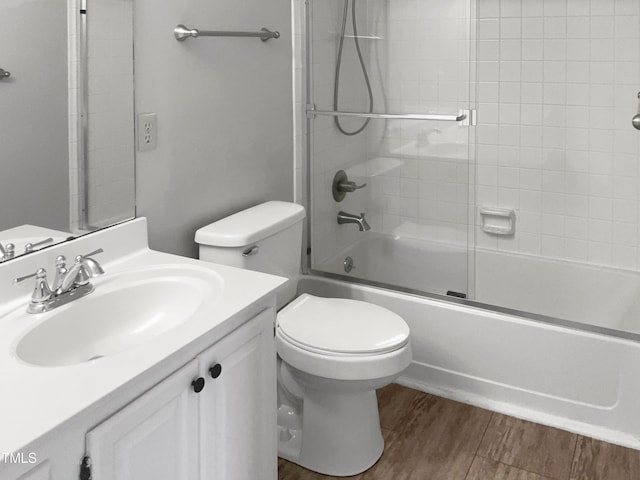 full bathroom featuring hardwood / wood-style flooring, toilet, bath / shower combo with glass door, and vanity