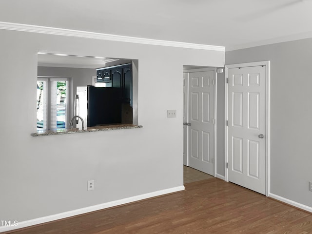 empty room with ornamental molding, dark hardwood / wood-style flooring, and sink