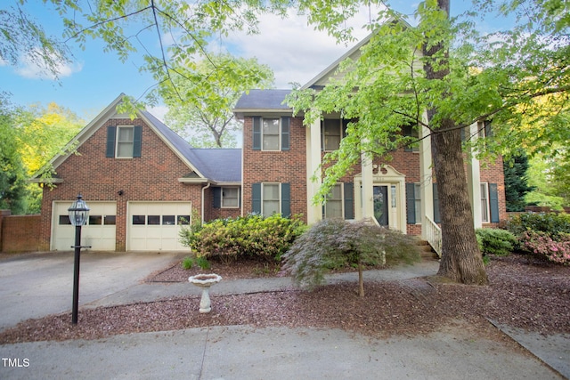 neoclassical home featuring concrete driveway and brick siding