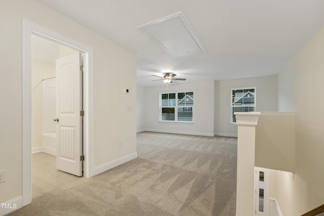 spare room with ceiling fan and light colored carpet