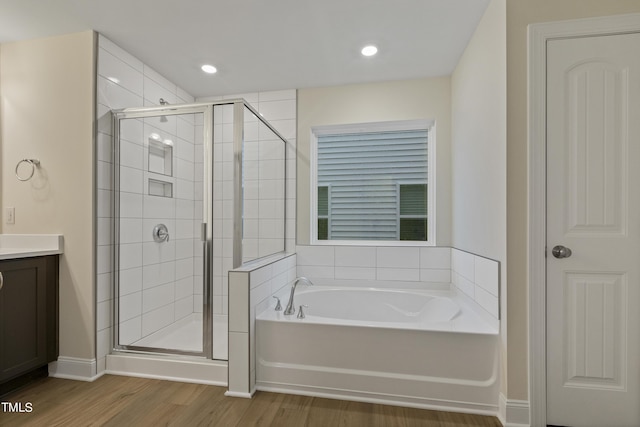 bathroom with shower with separate bathtub, vanity, and hardwood / wood-style floors