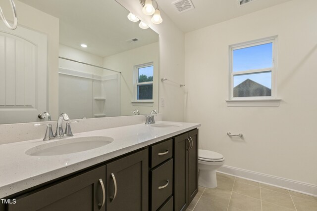 bathroom with toilet, tile patterned flooring, walk in shower, and vanity