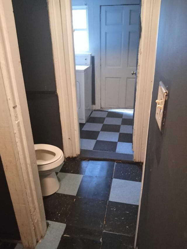 bathroom featuring tile flooring, toilet, and washer / clothes dryer