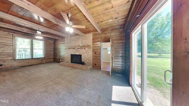 unfurnished living room with wood walls, carpet flooring, beam ceiling, wood ceiling, and ceiling fan