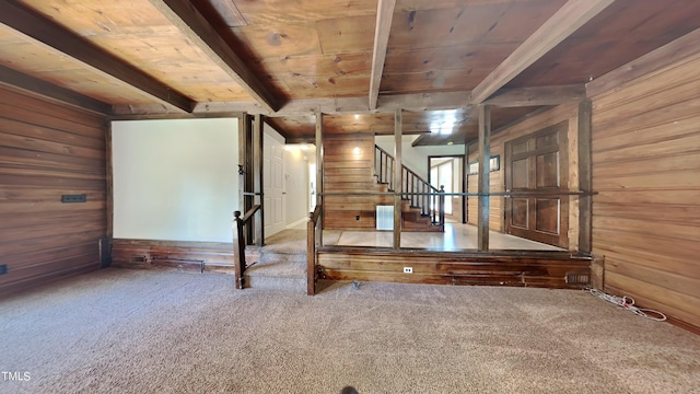 interior space featuring wood walls, wooden ceiling, beam ceiling, and carpet floors