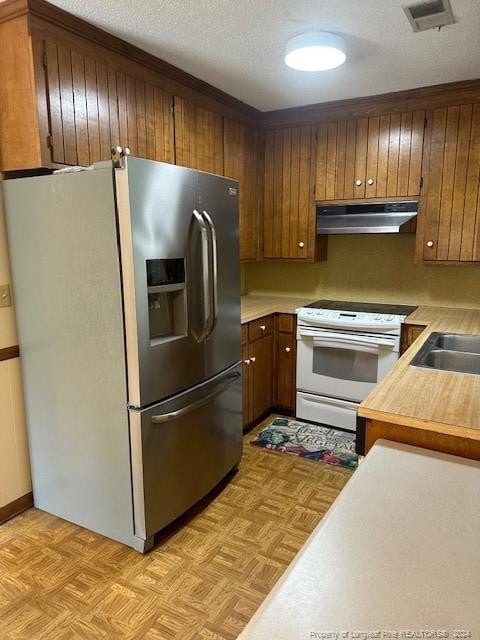 kitchen with white range with electric cooktop, stainless steel fridge, sink, and light parquet flooring