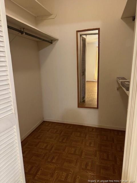 spacious closet with dark parquet floors