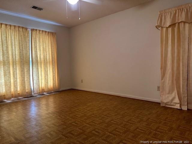 unfurnished room featuring dark parquet floors and ceiling fan