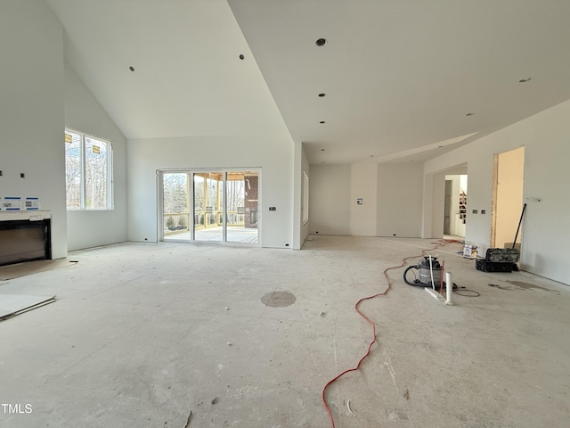 unfurnished living room featuring high vaulted ceiling