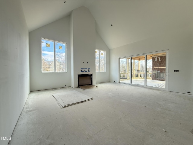 unfurnished living room with high vaulted ceiling