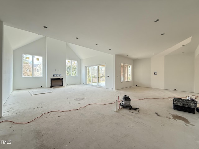 unfurnished living room with high vaulted ceiling