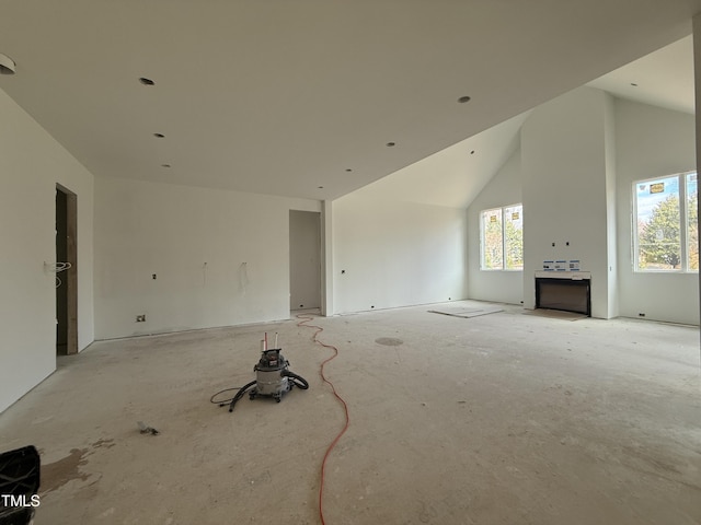 unfurnished living room with high vaulted ceiling