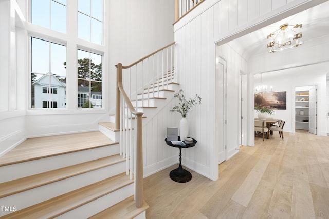 foyer featuring a high ceiling, a notable chandelier, and light wood-type flooring