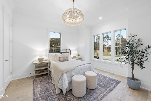 bedroom with multiple windows, ornamental molding, a notable chandelier, and light hardwood / wood-style floors