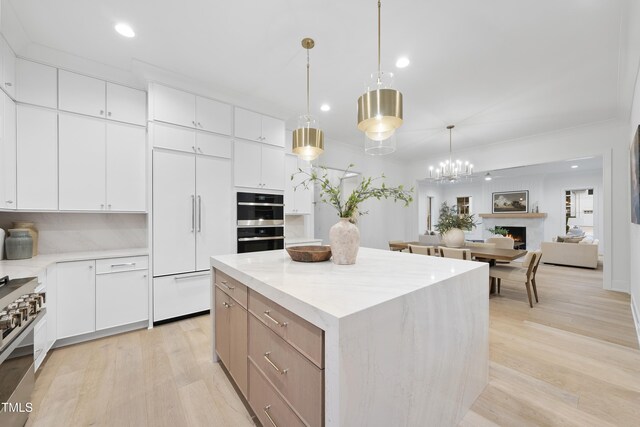 kitchen featuring white cabinetry, hanging light fixtures, stainless steel appliances, and a kitchen island