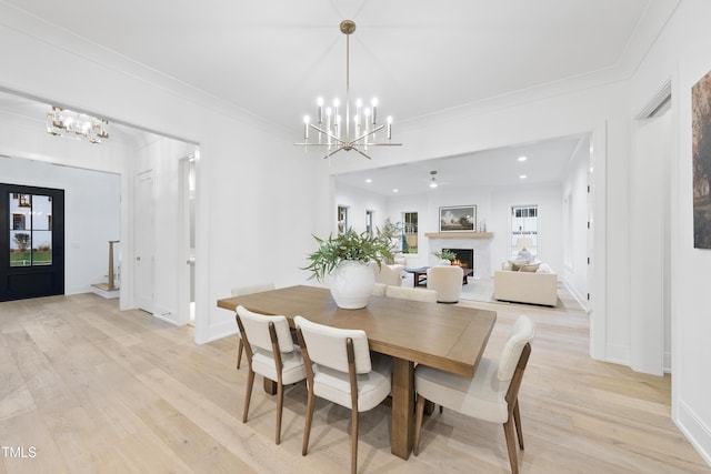 dining area featuring crown molding, a chandelier, and light hardwood / wood-style flooring