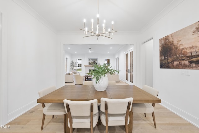 dining room featuring crown molding, a chandelier, and light wood-type flooring