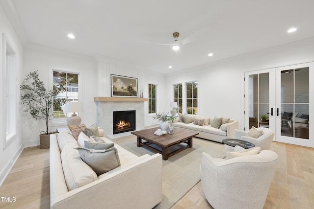 living room featuring french doors, ceiling fan, crown molding, and light wood-type flooring