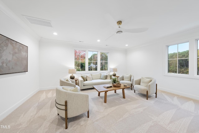 carpeted living room with crown molding and ceiling fan