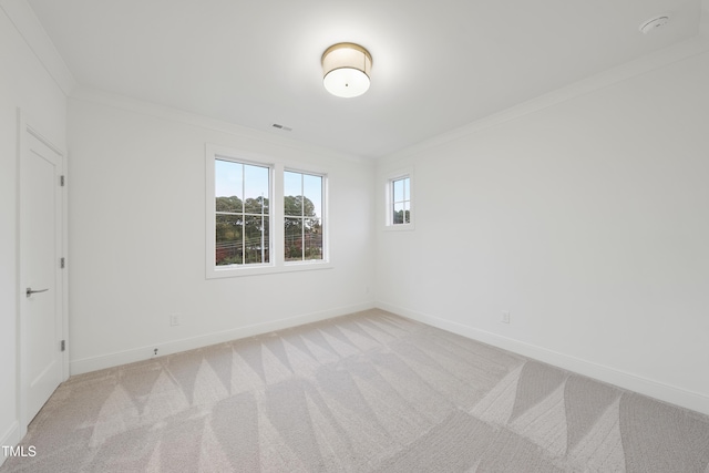 spare room featuring ornamental molding and light colored carpet