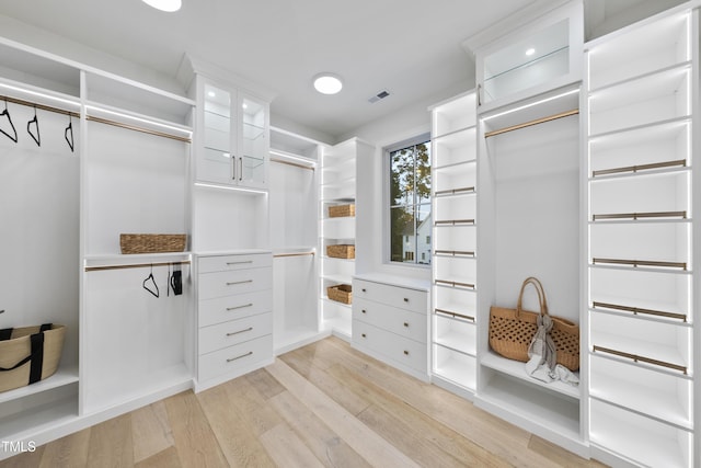 walk in closet with light hardwood / wood-style flooring