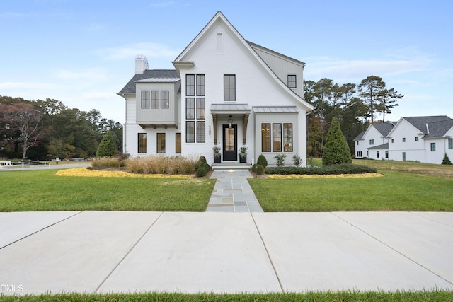 modern farmhouse style home featuring a front yard