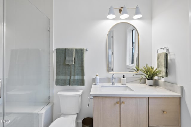 bathroom with vanity, toilet, and a shower with shower door