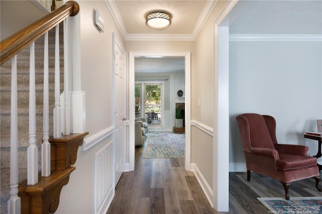 hall featuring crown molding, dark hardwood / wood-style floors, and a textured ceiling