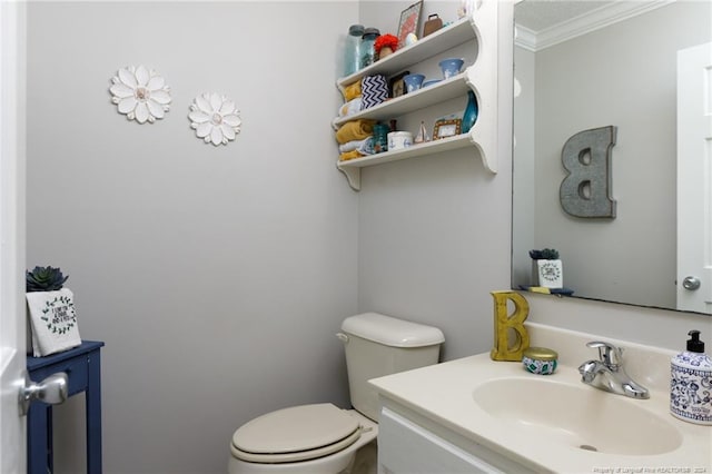 bathroom with vanity, toilet, and ornamental molding