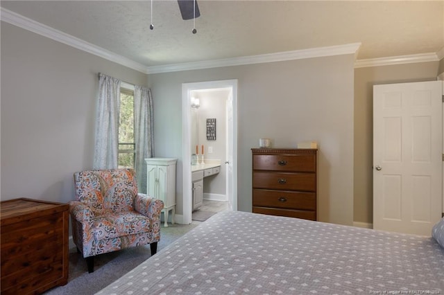 carpeted bedroom featuring ornamental molding, ceiling fan, and ensuite bath