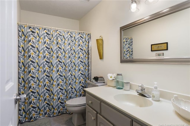 bathroom featuring toilet, tile floors, and vanity