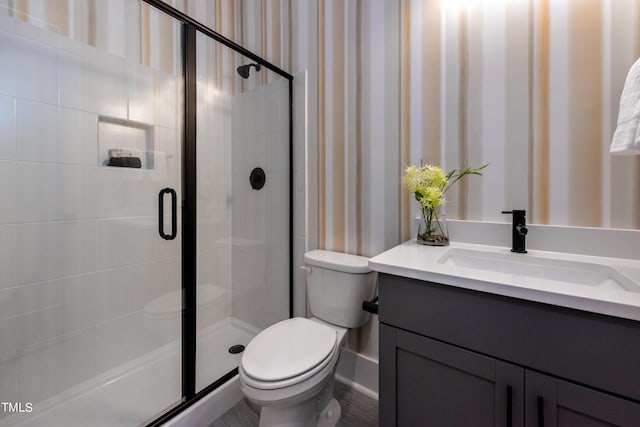 bathroom featuring toilet, vanity, and an enclosed shower