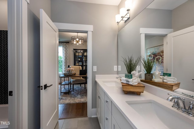 bathroom with tile patterned flooring, vanity, and a notable chandelier