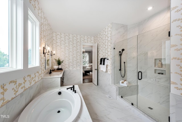 bathroom with plenty of natural light and separate shower and tub