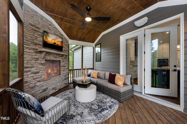 wooden terrace featuring ceiling fan and an outdoor living space with a fireplace