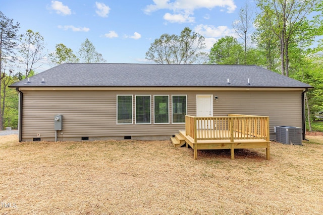 back of property with a yard, a wooden deck, and central air condition unit