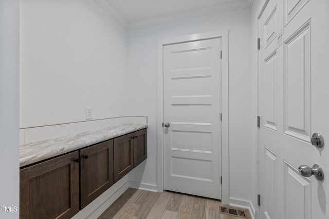 bathroom with ornamental molding and hardwood / wood-style floors