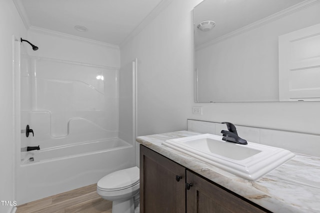 full bathroom with large vanity, hardwood / wood-style floors, bathtub / shower combination, crown molding, and toilet