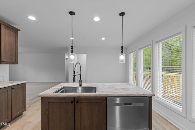 kitchen featuring decorative light fixtures, light hardwood / wood-style flooring, sink, light stone counters, and dishwasher