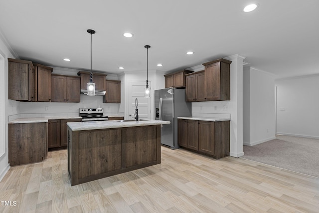 kitchen with appliances with stainless steel finishes, light carpet, sink, decorative light fixtures, and a center island with sink