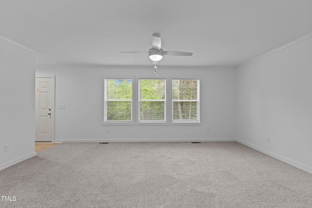 unfurnished room with light colored carpet, ceiling fan, and crown molding