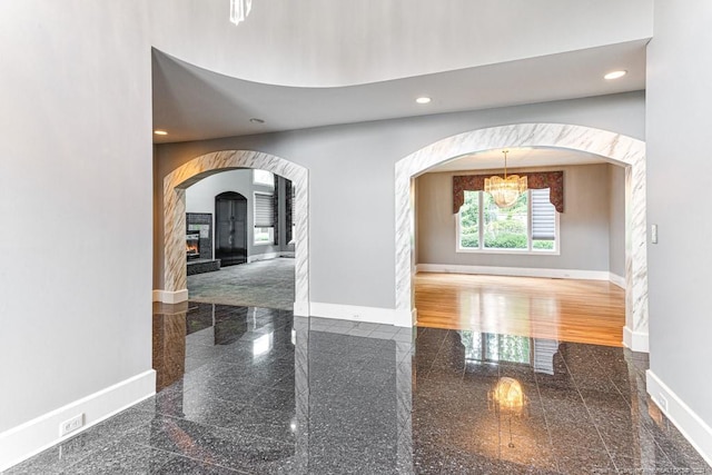 hallway featuring an inviting chandelier and wood-type flooring